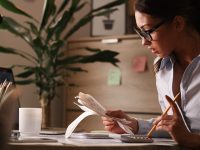 Female accountant calculating tax bills while working on finances in the office.