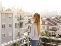 Woman standing and relaxing on balcony